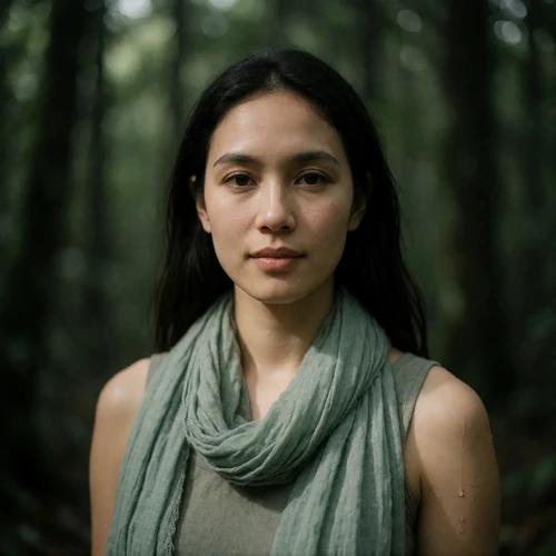 Bruneian woman in her early thirties in a soft green scarf with a serene outdoor expression