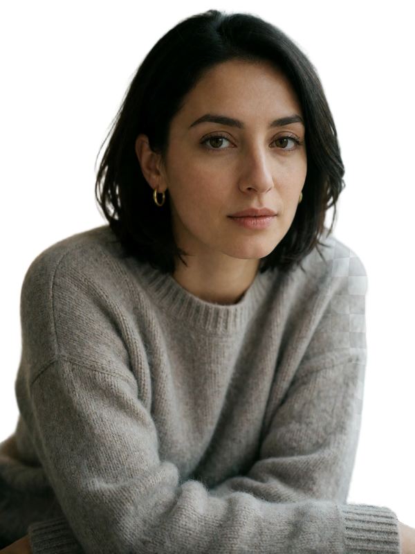 Armenian woman in a soft grey cashmere sweater with a thoughtful expression
